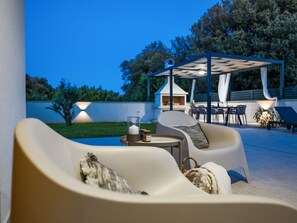 An outdoor seating area with a pool, a covered patio, and a barbecue grill. - Villa Arboria with heated pool by Interhome (Zaton)