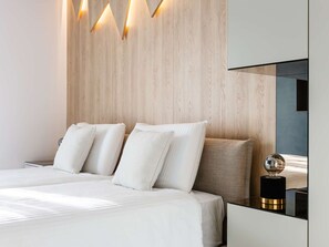 A modern bedroom with a wooden headboard, a large bed with white bedding, and a bedside table with a spherical object. - Luxury Villa Positiva with heated pool by Interhome (Vir)
