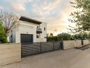 A modern two-story house with a garage, a balcony, and a gated driveway. - Luxury Villa Positiva with heated pool by Interhome (Vir)