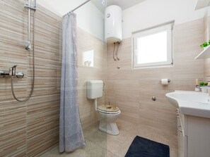 Ein modernes Badezimmer mit Dusche, Toilette und Waschbecken.