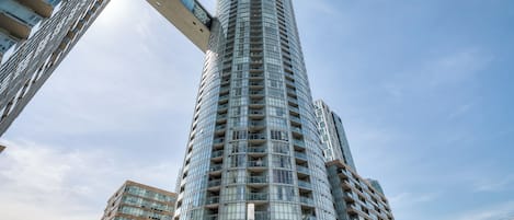 Un grand immeuble de bureaux de forme cylindrique, doté de nombreux balcons et de grandes fenêtres.