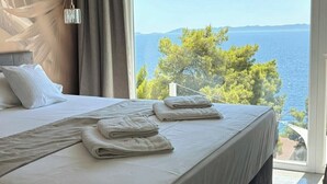 Ein Schlafzimmer mit einem großen Bett, Meerblick und modernem Design.