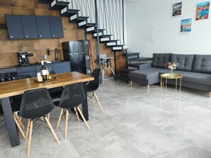 A modern kitchen with a dining area, a sofa, and a coffee table. - Coral Cove 1 (Blato)