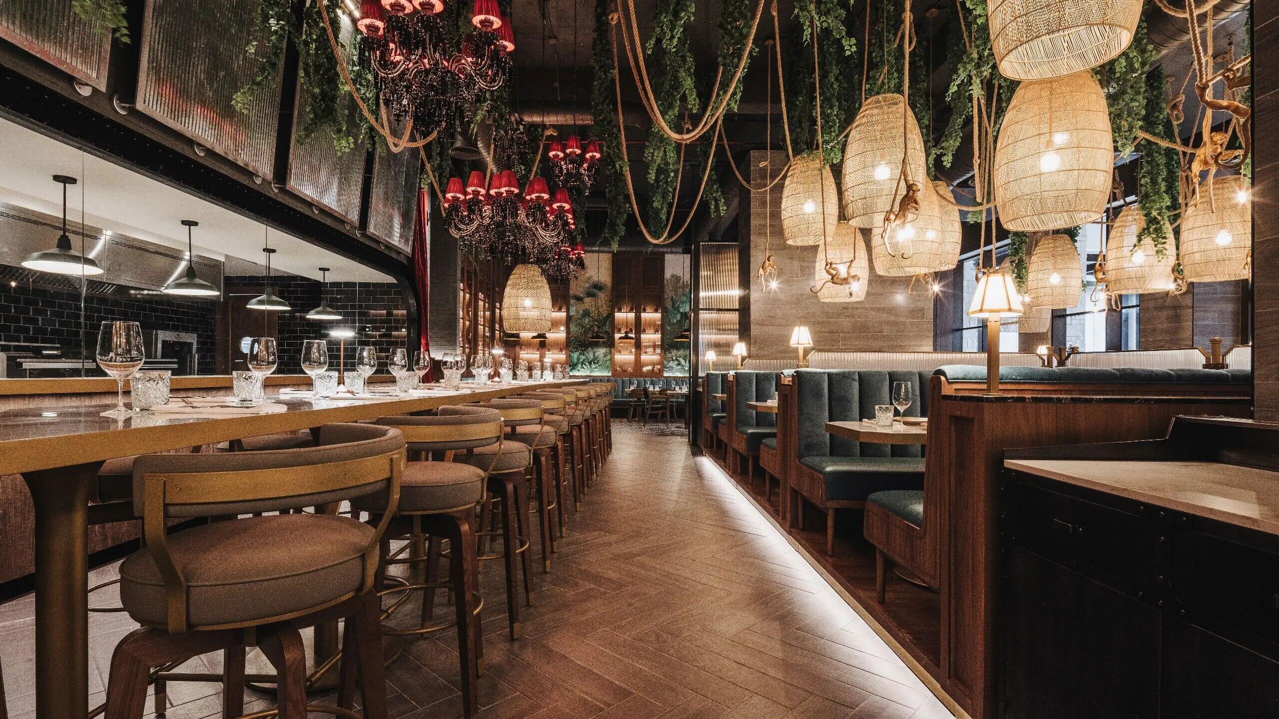 L’intérieur d’un restaurant présente un long bar, plusieurs espaces de détente et des luminaires suspendus.