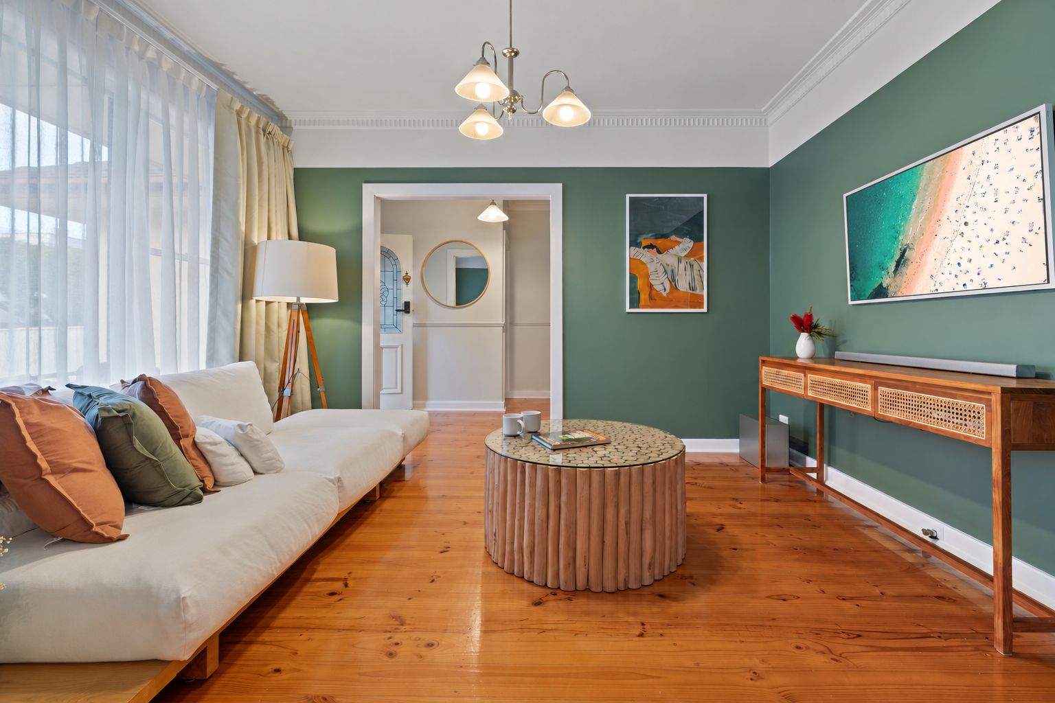 A living room with a sofa, round coffee table, and artwork on the walls.