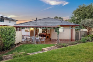 A residential property with a covered patio, a dining area, and a kitchen.