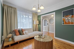 A modern living room with a sofa, a coffee table, and a painting on the wall.
