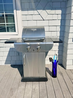 A stainless steel barbecue grill with a black control panel, placed on a wooden deck. - "The Launch” Beach Cottage on Camano Island (Camano)