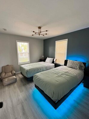 A bedroom with two beds, a chair, and a ceiling light fixture. - Brand New Stunning Home 3 min to Niagara Falls (Niagara Falls)