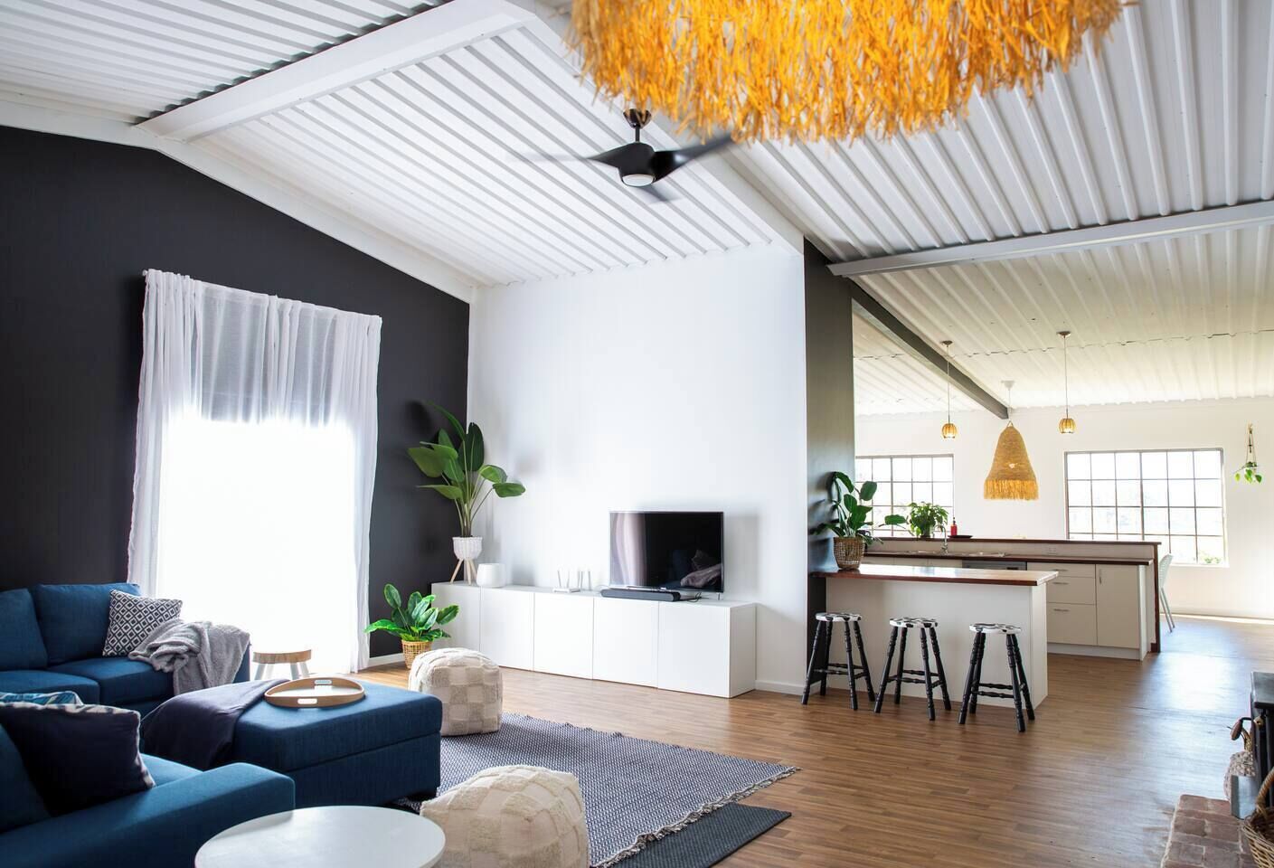 A modern living space with a sofa, coffee table, and a TV on a white cabinet.
