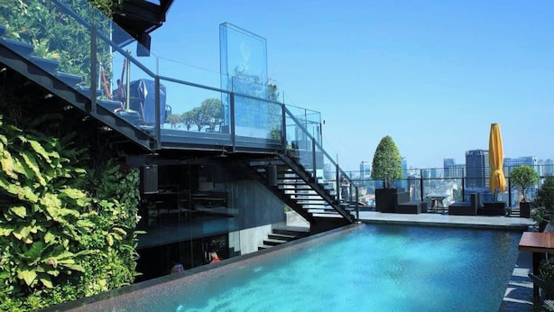 A rooftop pool with glass railings, a staircase, and outdoor seating. - IMPERIAL JADE SUITE at THE ONE SAIGON (Ho Chi Minh City)