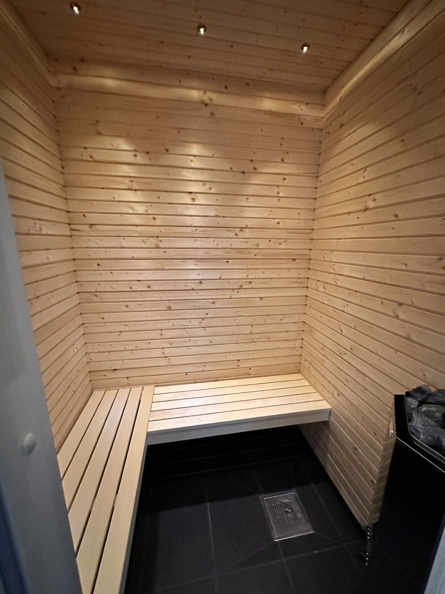 Un sauna con paredes de madera y un banco.
