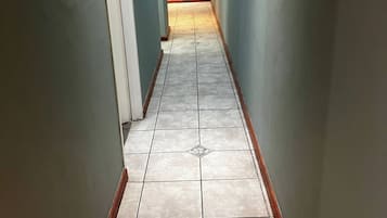 A narrow hallway with light blue walls and a tiled floor.