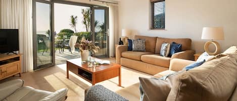 A modern living room with a sofa, coffee table, and a television.