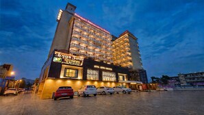 Un hotel de varios pisos, un restaurante y un área de estacionamiento.