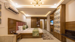 Una habitación de hotel moderna con una cama grande, un televisor, un armario y un espacio para sentarse.