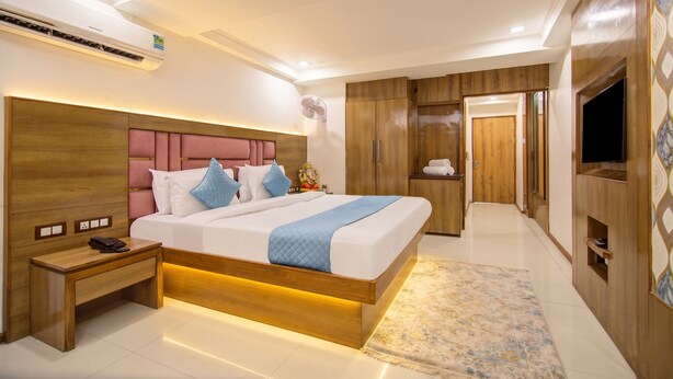 Un dormitorio moderno con una cama grande, mesitas de noche, un televisor y un armario.