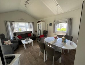 Ein Wohnzimmer mit einer Couch, Stühlen, einem Tisch und einem Essbereich.