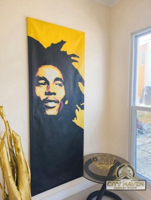 Pintura de una persona con el rostro desenfocado, un adorno dorado y el logotipo de CITY HAVEN LUXURY STAYS.