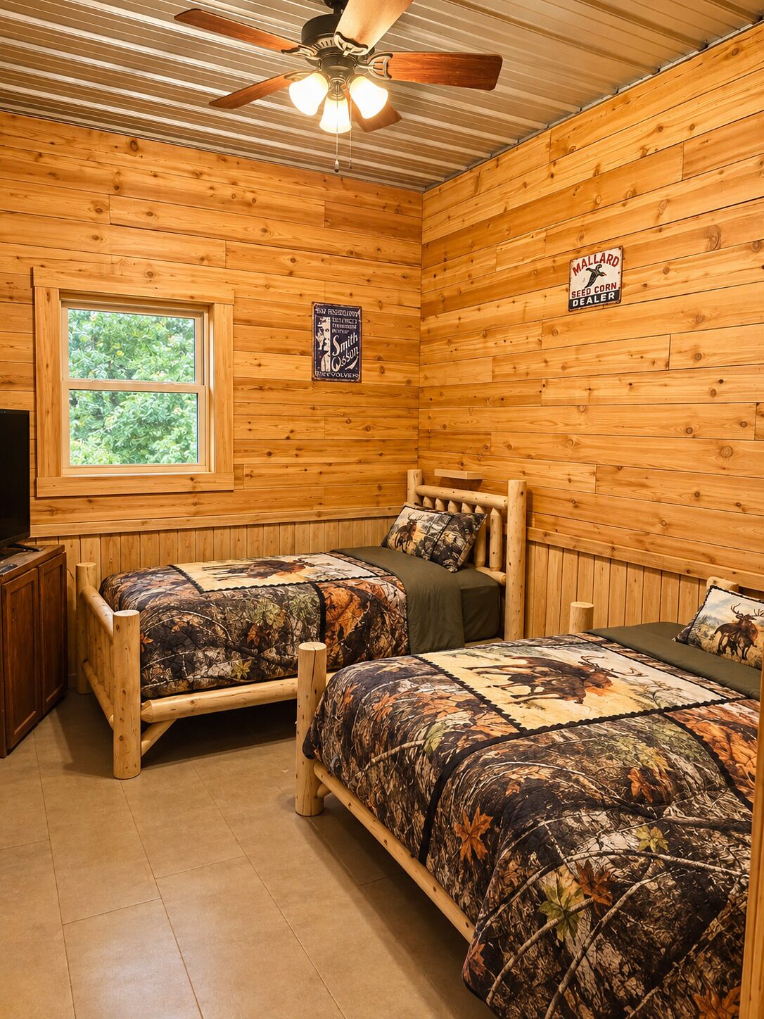 A cabin with two wooden beds, a ceiling fan, a window, and a sign for a seed corn dealer.