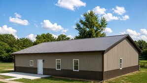 A single-story metal building with a flat roof, a door, and two windows.