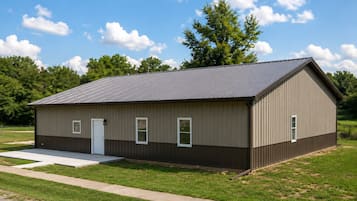 A single-story metal building with a flat roof, a door, and two windows.