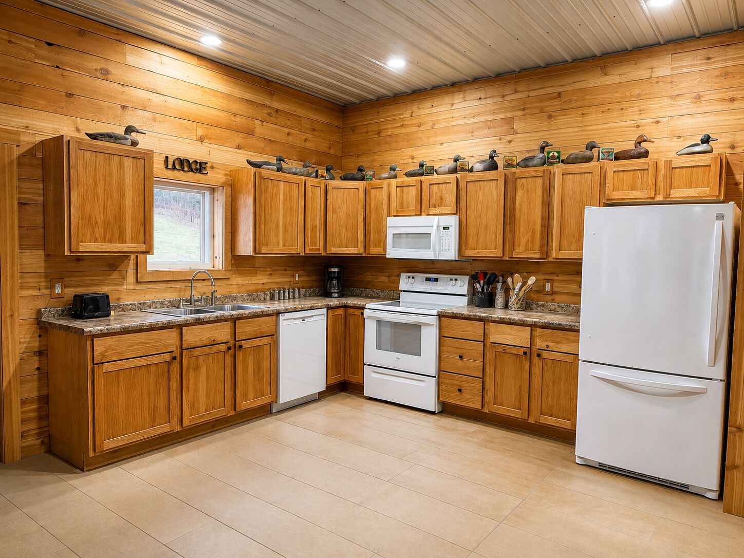 Una cocina con armarios de madera, microondas, estufa y refrigerador.