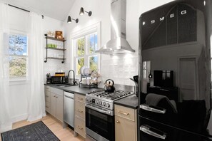 Eine moderne Küche mit Herd, Backofen und einem schwarzen Kühlschrank.
