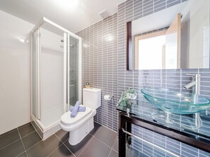 A modern bathroom with a glass sink, a toilet, and a shower area. - Oliva Nova Cabagua by Interhome (Oliva)