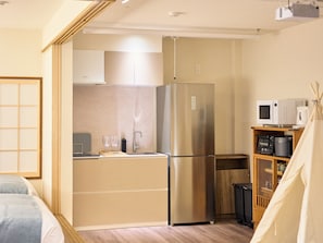 A compact kitchen with a refrigerator, microwave, and a small cabinet. - KONJAKUSO Osaka Bentencho "OKUJO-TEIEN" Rooftop Garden (大阪市港区弁天4丁目)
