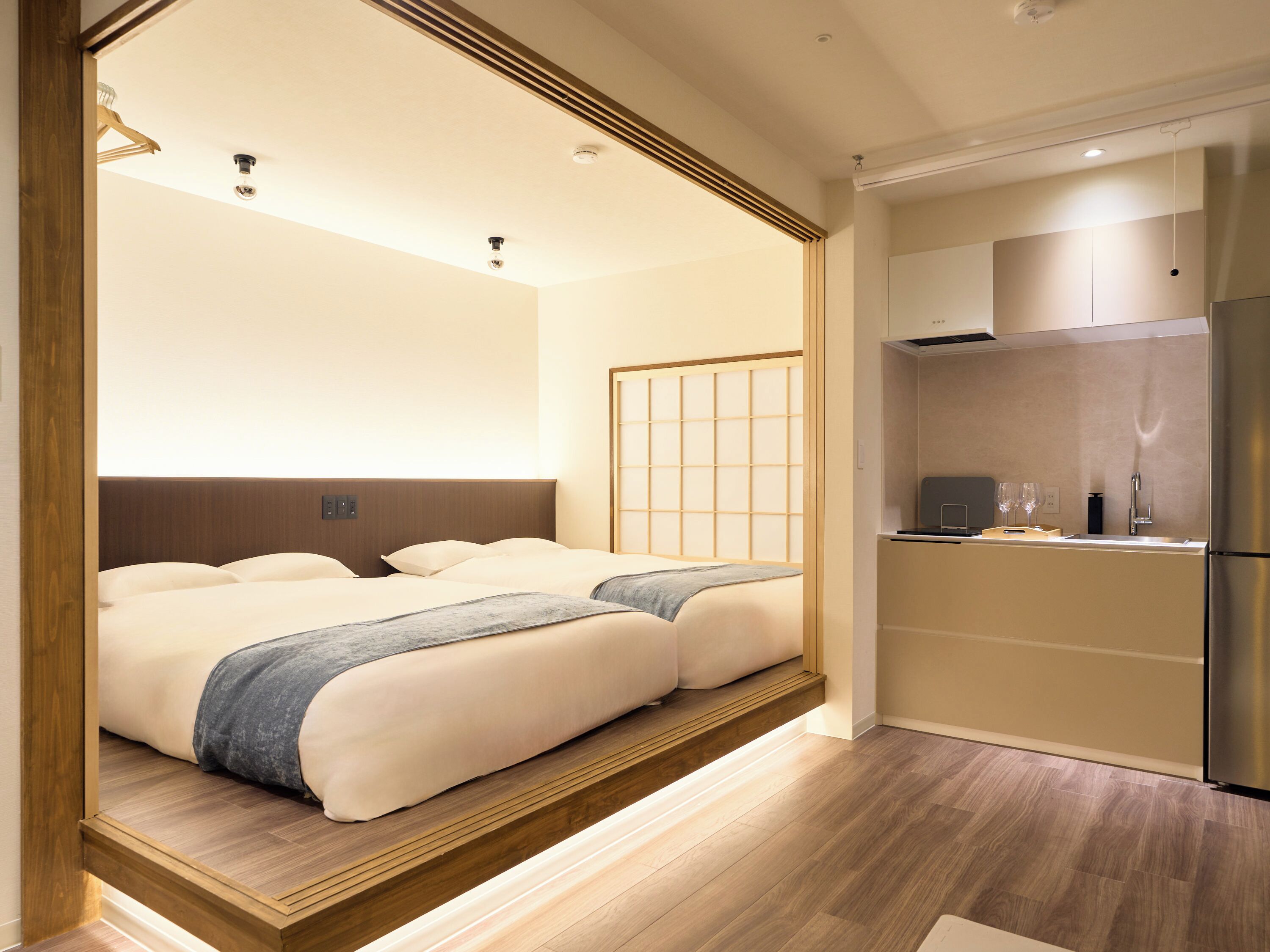 Ein Hotelzimmer mit einem Bett, einer kleinen Küchenzeile und Holzboden.