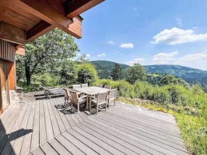 A wooden deck with a table and chairs, overlooking a mountainous landscape. - Wellness Retreat Labská by Interhome (Spindleruv Mlyn)