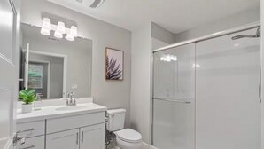 A modern bathroom with a white sink, toilet, and shower. - Breathtaking Modern Hillside Suite (San Jose)