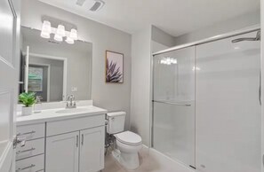 A modern bathroom with a white sink, toilet, and shower. - Breathtaking Modern Hillside Suite (San Jose)
