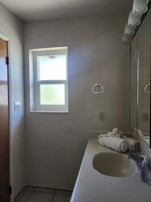 A bathroom with a window, a sink, a towel rack, and a mirror. - Gauche Point Guest House
Breathtaking Scenic Lake View (Mountain Mesa)