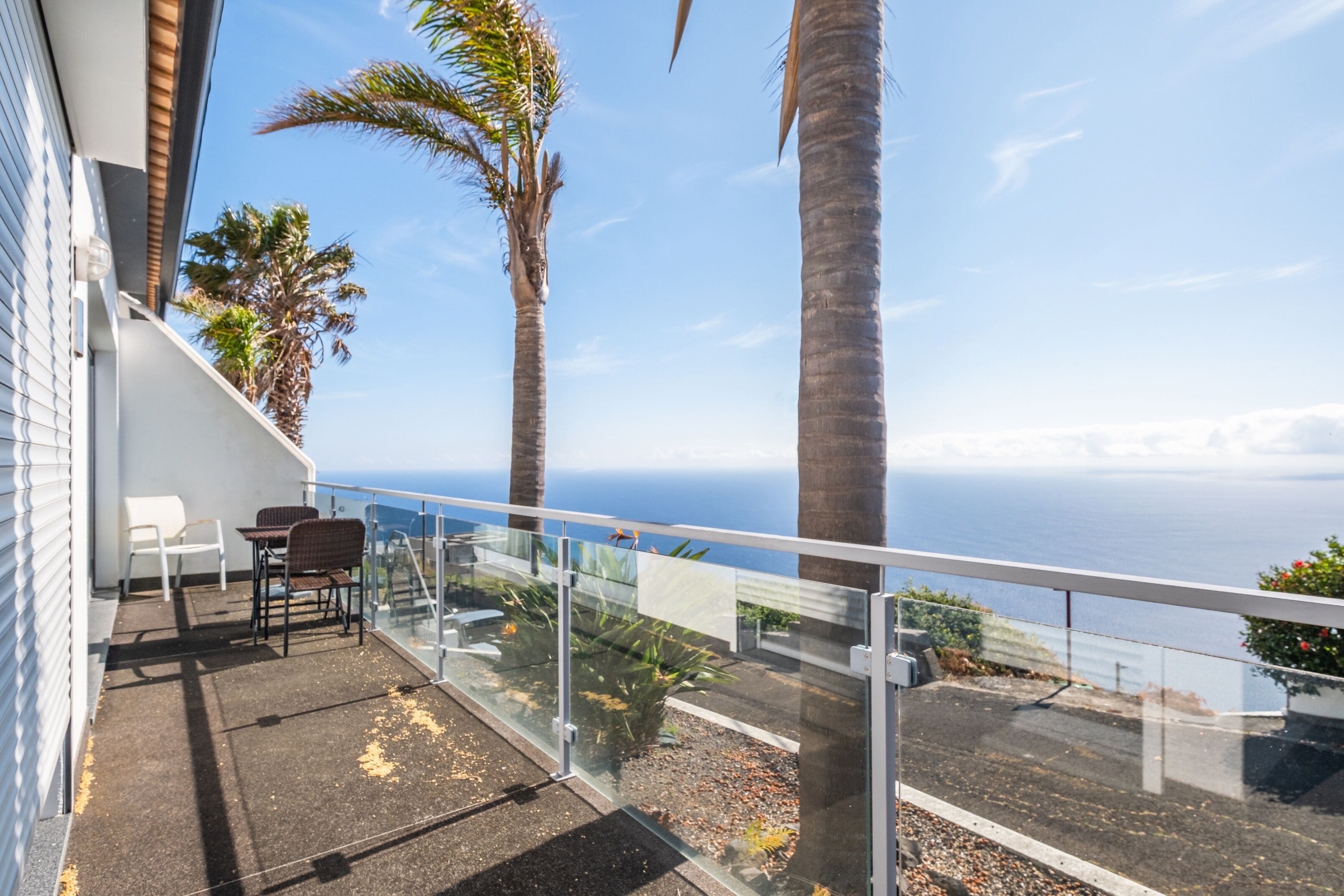 Ein Balkon mit Glasgeländer und Blick auf die Küste.