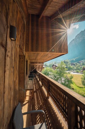 A wooden balcony with a view of a mountainous landscape. - 2-Bedroom Apartment with Mountain Views (Châtel)