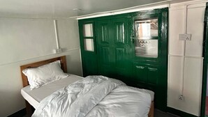 A room with a bed, a wardrobe, and a green door.
