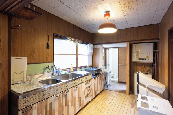 A kitchen with wooden cabinets, a sink, a stove, and a refrigerator.