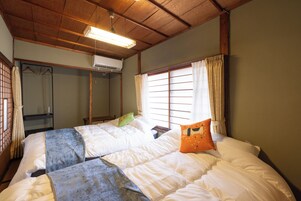 A room with a bed, a wardrobe, and a window with curtains.