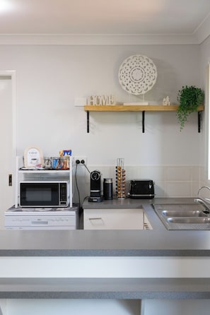 A kitchen with a microwave, toaster, and coffee maker on the counter.