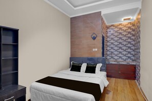 A bedroom with a bed, a wardrobe, a wall-mounted light fixture, and a tiled wall. - Cozy Standard Room in Badung (Mengwi)