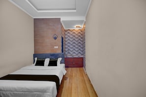 A hotel room with a bed, a small table, and a wall-mounted heater. - Cozy Standard Room in Badung (Mengwi)