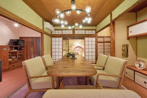 Ein traditioneller japanischer Raum mit Tatami-Boden, einem Holztisch und einem Shoji-Bildschirm.