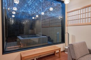 Ein modernes Zimmer mit großem Fenster, einer Holzbank und einer Sitzecke.