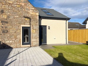 A stone building with a modern extension, a door, and a fenced yard. - The Cottage by Interhome (Lossiemouth)
