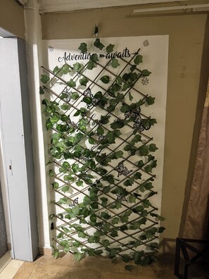 A wall with a climbing plant and decorative metalwork.