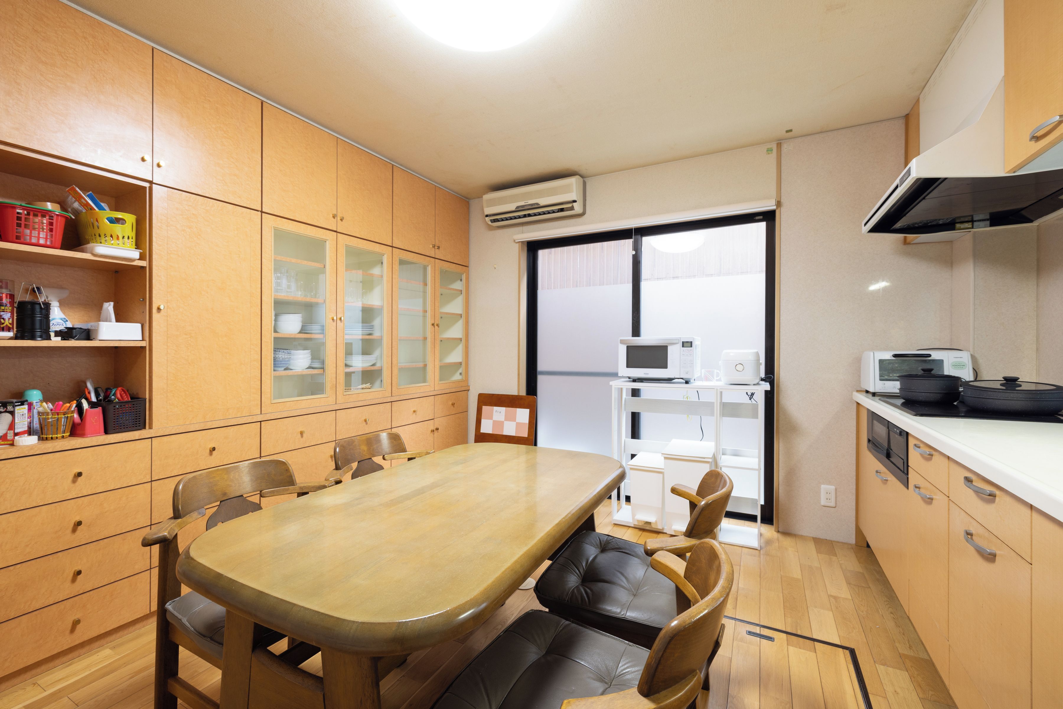 A compact kitchen with a dining table, chairs, and a microwave.