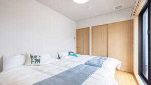 Ein Schlafzimmer mit zwei Betten, einem Fenster und einem Kleiderschrank.