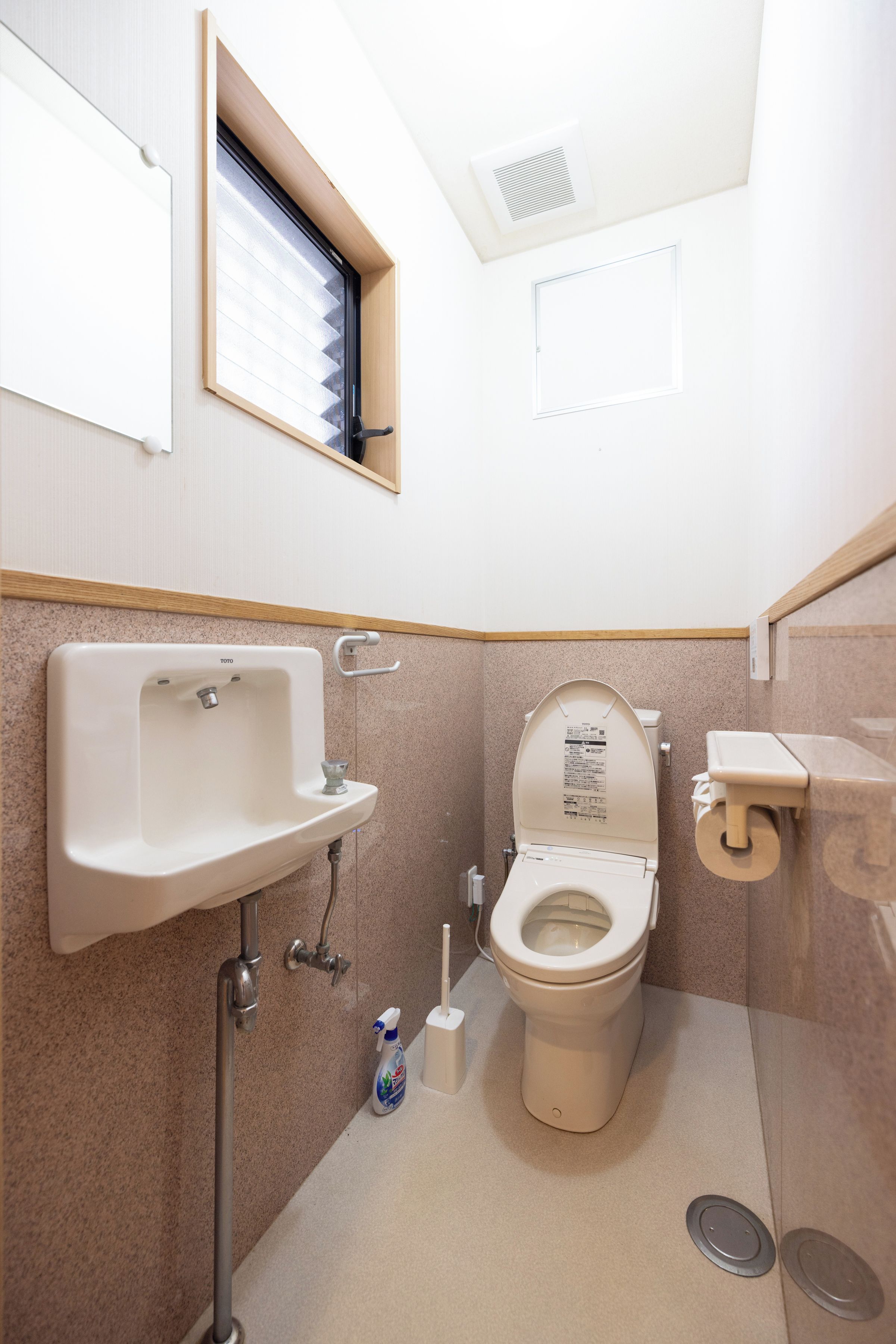 A small, clean bathroom with a toilet, sink, and window.
